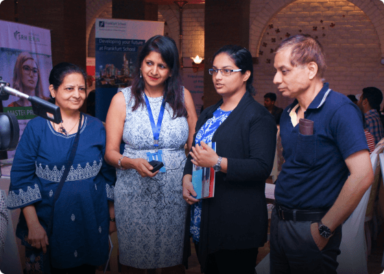 A student expressing herself while surrounded by a counsellor and her parents at an exhibition.